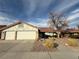 Single-story house with three-car garage, landscaped yard, and a walkway at 8608 Alfano Ct, Las Vegas, NV 89117