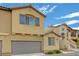 Tan two-story house with gray garage door and satellite dish at 1132 Via Fellini, Henderson, NV 89052