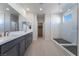 Modern bathroom with double vanity, large mirror, and walk-in shower at 178 May Park Ave, Henderson, NV 89011