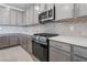 Modern kitchen with stainless steel appliances and gray cabinets at 178 May Park Ave, Henderson, NV 89011