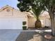 House exterior with a white garage door and a large pineapple plant at 7213 Robins Roost St, Las Vegas, NV 89131