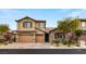 Two-story house with tan exterior, double garage, and landscaping at 7563 Saguaro Cactus Ave, Las Vegas, NV 89178