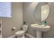 Small powder room with pedestal sink and oval mirror at 3428 Isle Dr, Las Vegas, NV 89141