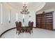 Elegant dining area with a round glass table, chandelier, and built-in shelving at 3888 W Pebble Rd, Las Vegas, NV 89139