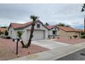 Front view of a single story home with palm trees and a two-car garage at 9004 Pennystone Ave, Las Vegas, NV 89134