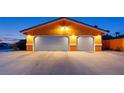 Three-car garage with white doors and exterior lighting at 423 Cannes St, Henderson, NV 89015