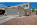 Two-story house with a white garage door and a gravel front yard at 7512 Maiden Run Ave, Las Vegas, NV 89130