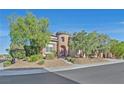 Two-story home with a turret and landscaping at 10038 Peak Lookout St, Las Vegas, NV 89178