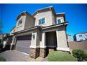 Two-story house with a large garage and stone accents at 6943 Nash Tracks St, North Las Vegas, NV 89084