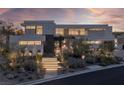 Modern home exterior with landscaped grounds and illuminated staircase at 9 Boulderback Dr, Henderson, NV 89012