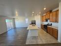 Modern kitchen with island, stainless steel appliances, and wood cabinets at 9356 Newbattle St, Las Vegas, NV 89178