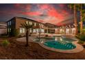 Inviting pool and spa area with string lights and outdoor kitchen at 7338 Flying Pegasus Ct, Las Vegas, NV 89131