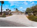 Ranch-style home with three-car garage and landscaped yard at 6356 Canyon Ridge Dr, Las Vegas, NV 89108