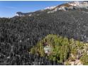 Aerial view of a house nestled in a mountainous forest setting at 0 Apn 128-07-201-016 N Fork Deer Creek, Mount Charleston, NV 89124