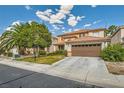 Two-story house with a brown garage door and lush green lawn at 7566 Catalina Harbor St, Las Vegas, NV 89131