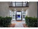 Modern glass front door entry with a walkway flanked by bushes at 4181 Bronze Ridge St, Las Vegas, NV 89135