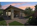 Relaxing covered patio with pavers and a grassy area at 10057 Regency Canyon Way, Las Vegas, NV 89148