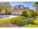 Two-story house with three-car garage and lush landscaping at 1002 Prestige Meadows Pl, Henderson, NV 89052