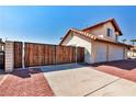 Two story home with wooden gate and brick driveway at 2195 River City Dr, Laughlin, NV 89029