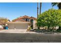 Two-story house with three car garage, mature landscaping, and a brick pathway at 1834 Escondido Ter, Henderson, NV 89074