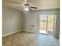 Living room with tile flooring, ceiling fan, and sliding glass door access to patio at 5378 Swenson St # 21, Las Vegas, NV 89119