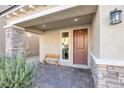 Front porch with a wooden bench and brick pavement at 8739 Scalpay St, Las Vegas, NV 89166