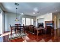 Open living and dining area with hardwood floors, a fireplace, and a modern chandelier at 9209 Tudor Park Pl, Las Vegas, NV 89145