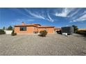 Rear exterior view of house showcasing a patio area and desert landscape at 6430 Wagon Wheel Ct, Pahrump, NV 89061