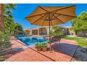 Inviting swimming pool with patio furniture and umbrella at 6527 Lokai Ave, Las Vegas, NV 89130