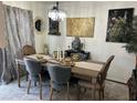 Elegant dining room with a wood table, gray chairs, and a crystal chandelier at 526 Sellers Pl # 0, Henderson, NV 89011