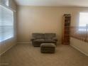 Spacious living room featuring a couch, ottoman, and built-in shelving at 8305 Woodland Prairie Ave, Las Vegas, NV 89129