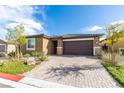 Single-story home with a two-car garage and landscaped yard at 4211 Callisto Ave, North Las Vegas, NV 89084