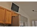 Kitchen with wood cabinets and a flat-screen TV above the refrigerator at 3416 Bonn Ct, Las Vegas, NV 89130