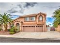 Two-story house with tan exterior, three-car garage, and nicely landscaped yard at 2728 Aspen Wood Ave, Henderson, NV 89074