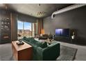 Spacious living room featuring a green sofa and city views at 200 Hoover Ave # 1502, Las Vegas, NV 89101