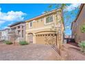 Two-story home with tan exterior and paver driveway at 7762 Tyrell Peaks St, Las Vegas, NV 89139