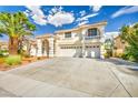 Two-story house with a landscaped yard, arched entryway and three-car garage at 9208 November Breeze St, Las Vegas, NV 89123