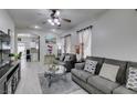 Spacious living room with gray sofas, coffee table, and hardwood floors at 925 Shining Rose Pl, Henderson, NV 89052