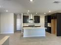 Modern kitchen with island, dark cabinetry, and quartz countertops at 11414 Ethereal Landing Ave, Las Vegas, NV 89138