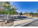 Ranch style home with white fence and mature trees at 7045 Eldora Ave, Las Vegas, NV 89117