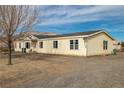 Single-story home with light-colored siding and mature trees at 1630 Nye Rd, Pahrump, NV 89060