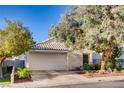 One-story home with a white garage door and mature trees in the front yard at 8665 Freeport Ln, Las Vegas, NV 89117