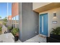 Modern two-story home with a teal front door and small patio at 9807 Ravenstone St, Las Vegas, NV 89141