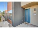 Modern two-story home with a teal front door and small patio at 9807 Ravenstone St, Las Vegas, NV 89141