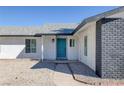 Front entrance with teal door and dark brick accents at 5264 Lookout St, Las Vegas, NV 89120