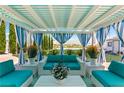 Covered patio area with teal seating and striped curtains at 40 Palm Garden Dr, Palm Gardens, NV 89039