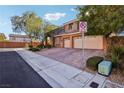 Two-story house with tan exterior, brick driveway, and street view at 8001 Pavarotti Ave, Las Vegas, NV 89178