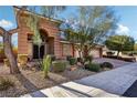 Two-story house with tan exterior, landscaping, and a tree in front at 8001 Pavarotti Ave, Las Vegas, NV 89178