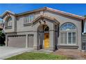 Two story house with a two car garage and a wooden door at 8216 Fawn Heather Ct, Las Vegas, NV 89149