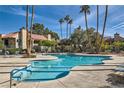 Inviting community pool with surrounding lounge chairs and palm trees at 4742 Obannon Dr # B, Las Vegas, NV 89102